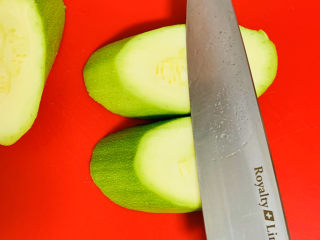 3、醋溜西葫芦,再将切好的厚片停放在案板上，再次45度角斜切。