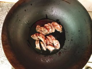 5、腊肠包菜小炒,油烧一点点热时就加入香肠，转小火慢慢煎熟。。千万别把油烧冒烟了，那样煎腊肠很容易糊了并很干，影响口感！