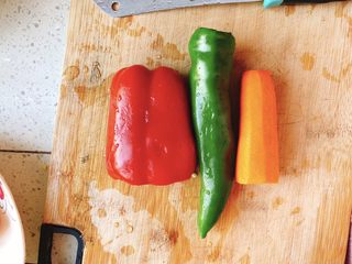 1、能吃两碗饭的下饭菜-宫保鸡丁,准备青尖椒、胡萝卜、红彩椒，清洗干净。