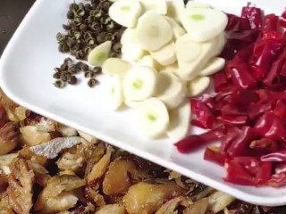 5、爆炒鲅鱼,炒香后放花椒，蒜片，干辣椒，料酒炒出麻辣味