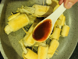 16、豆皮金针菇卷,转小火，调料均匀的浇在每个豆皮金针菇卷上