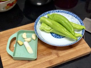 5、嫩绿纷红不自愁➕尖椒木耳回锅肉,准备好五花肉，再来处理蔬菜。蒜剥皮姜去皮与葱白洗净。尖椒去蒂去籽洗净，怕辣的记得把尖椒的筋撕去