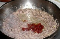 3、自制四川臊子,加入剁碎的郫县豆瓣，继续翻炒；