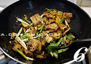 6、窝头回锅肉,放入蒜苗炒至断生,视情况用少量的盐调味即可。