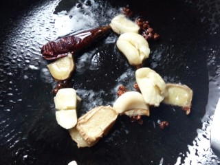 10、文师傅炒排骨,先下入花椒干辣椒炸香，再放入姜片、蒜片煸香。