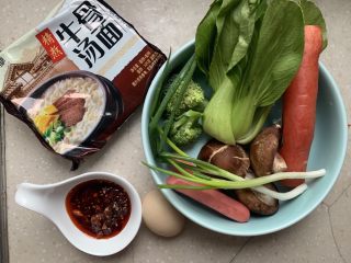 1、烤肠鸡蛋麻辣牛骨汤面,一次性准备好所有原材，方便面一包，麻辣调料一勺，鸡蛋一个、烤肠两根、彩蔬适量。彩蔬选择胡萝卜味、西兰花、瓢儿菜、香葱等，颜色搭配鲜艳，口感也很好。