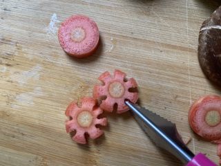 2、烤肠鸡蛋麻辣牛骨汤面,胡萝卜切片，再切成花朵。