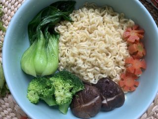 11、烤肠鸡蛋麻辣牛骨汤面,将煮熟的方便面倒入面碗中心，四周摆放彩蔬。