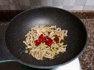 7、韭黄炒肉丝,放入泡椒泡姜翻炒出香味。