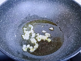 6、比肉还好吃的鸡汁炒平菇,起油锅，加入切好的蒜炒香。