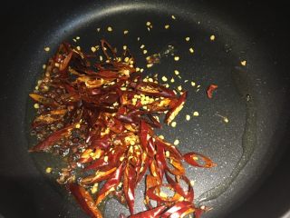 10、四川+酒鬼花生,倒出锅内多余的菜籽油，留一点点，倒入切丝的红辣椒和一小碟花椒粒，炒香