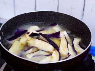 7、鱼香茄子,锅中倒入适量的食用油烧至六七成热时放入茄子炸软