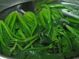 3、绿色美食麻酱果仁菠菜,捞出放入冷水中降温