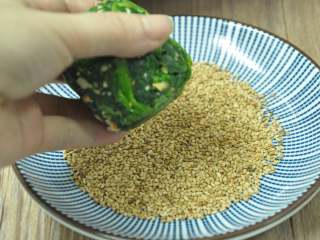 10、绿色美食麻酱果仁菠菜,取出菠菜，一头蘸上芝麻，另一面也蘸上芝麻