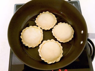 26、鸡蛋韭菜盒子,油烧到5分热的时候加入鸡蛋韭菜盒子生坯，全程小火煎制