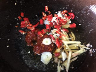 11、家常下饭鸭丝,再次升高油温后，下调料，郫县豆瓣一勺，其他也一起放进去，煸炒到浓烈香味。