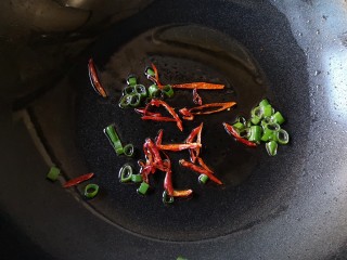 7、十味 双椒爆双耳,锅中适量油烧至7成热，下入葱花和干辣椒爆出香味。