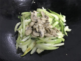 10、蘑菇炒菜梗,加入刚才炒过的蘑菇一起翻炒均匀。
