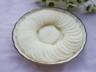 2、简单易做的剁椒蒸萝卜,白萝卜洗净去皮切片码入盘中。香葱切碎。