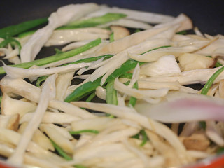 6、杏鲍菇炒鸡蛋,起油锅，把杏鲍菇与青椒倒下去同炒软；