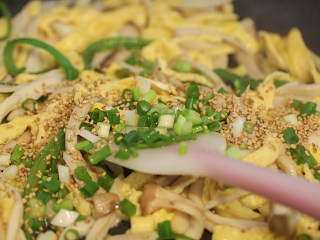9、杏鲍菇炒鸡蛋,撒上葱花和熟芝麻拌均匀起锅。