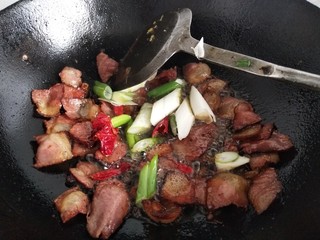 9、青椒腊肉片,加入葱和辣椒