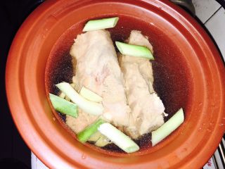 5、拆骨肉袋,放清水刚浸过骨头、放去皮姜片和洗净的葱段、放少许料酒、少许盐（葱姜没上图）
