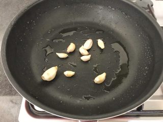 8、上汤芦笋,当油温5成热时，把大蒜粒加进来，