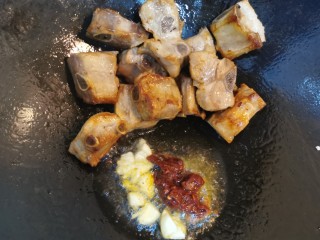 7、四季豆烧排骨,煎好的排骨搁至一侧，锅底油中加入姜、蒜、酱油、豆瓣酱爆香