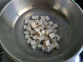 4、麻婆豆腐,起锅烧水，水开把豆腐放入煮一分钟。用开水焯豆腐可以去除豆腥味，也可以保持豆腐形状不易碎。