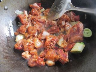 6、重庆鸡公煲,倒入腌渍好的鸡块。