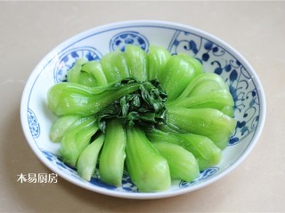 7、青菜炒火腿,将汆烫好的小油菜在盘中摆成一个圆形。小油菜茎部在外圈，叶子在内圈。