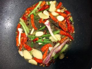 6、当红辣子鸡,放入干辣椒，倒少水许在锅中，继续炒香。（使味道融合）