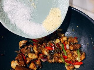 7、当红辣子鸡,倒入炸好的鸡腿，酱油、鸡精、白糖混合均匀。