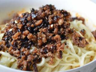 8、成都担担面#面条变身计划#,将面条盛在装底料的碗里面，肉臊浇在面条上面就可以了。