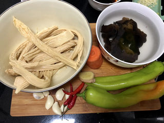 1、青椒炒腐竹➕岂有黄鹂历翠微,食材合照：泡发好的腐竹约250g（如果是干腐竹，要提前四五个小时，用冷水泡发），干木耳数朵，提前温水泡发，胡萝卜一小节，青椒两个，姜一小块，蒜六瓣，小米辣三个