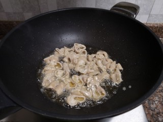 6、酸菜油豆腐烧肥肠,放入肥肠煸干水份。