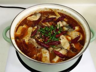 10、香辣水煮鱼,煮好后,将干料包、干辣椒和葱撒在鱼表面上。