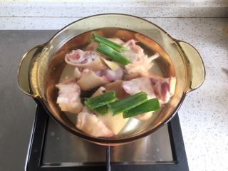 2、四川+老妈蹄花,猪蹄请农贸市场卖猪蹄的烧一下，洗干净，切大块。锅里加清水，倒入适量黄酒，加入大葱叶子、生姜片1片，冷水下猪蹄，大火