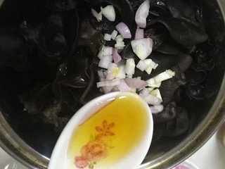 9、凉拌木耳,放在控干水的木耳上，淋上麻油。（不吃生蒜可以烧些热油浇在蒜末和圆葱丁上）