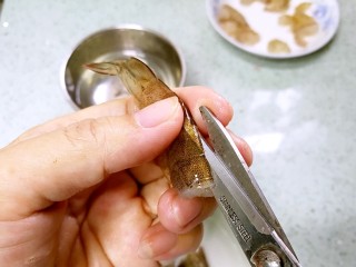 2、三珍炒虾球,剪开虾背。