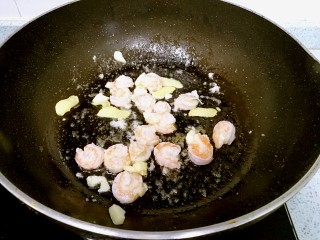 17、三珍炒虾球,锅里再倒一点油，爆香姜蒜，倒入虾仁，翻炒至成球状。