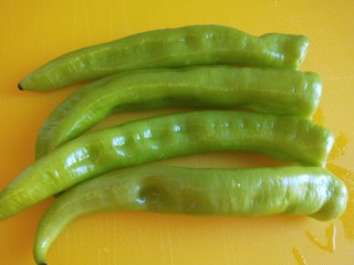 4、虎皮尖椒酿肉,放在案板去两头。