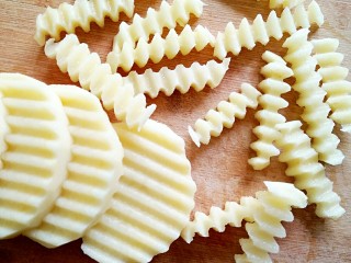 2、狼牙土豆（免油炸更健康）,土豆洗净去皮切片后用花刀切成长6厘米，宽1厘米左右的狼牙状土豆条。