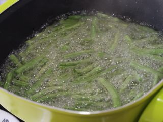 7、干煸豆角，素菜中的挖掘机,目的是炸出豆角中部分水份，这是中火煎炸一分钟后的样子，明显比刚下锅软了。