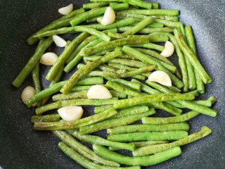 12、豆角烧茄子（少油健康版）,将豆角和蒜煸炒至外表变焦黄。