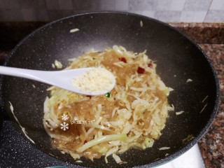12、卷心菜炒粉丝,放入适量鸡精翻炒均匀。
