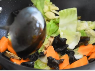 4、家常炒素，餐桌上最走俏的一道菜,热锅冷油，放入包心菜、黑木耳、香菇丝、胡萝卜、油面筋，炒至断生。