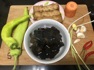 1、青椒炒素鸡,食材合照：素鸡约250g，青椒两个，木耳数朵凉水提前泡发，胡萝卜一节，小葱两根，小米辣三个，蒜四瓣，姜一小块，