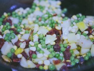 12、土豆香肠焖饭,依次加入土豆、香肠、豌豆和玉米粒，翻炒